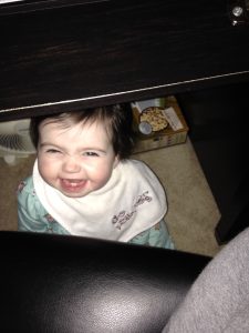 Smiling baby under a desk
